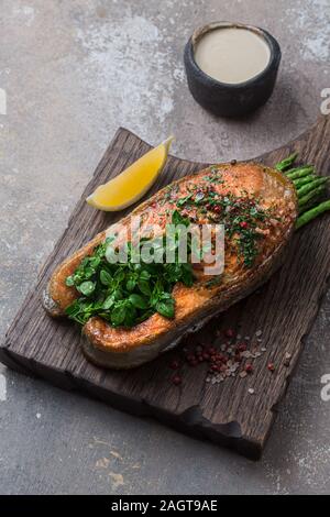 Pavé de saumon poêlé fermer voir avec des légumes sur planche de bois, copy space Banque D'Images