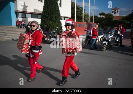 Malaga, Espagne. Dec 21, 2019. Deux femmes vêtues de costumes Père Noël faire des cadeaux avant le V de jouets Torremolinos.Des centaines de motocycliste se retrouvent chaque année au centre-ville de Torremolinos, à participer à une course de bienfaisance habillés en costumes de Père Noël et de la collecte de jouets pour les enfants. Credit : SOPA/Alamy Images Limited Live News Banque D'Images