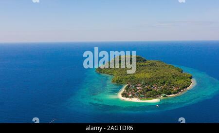Himokilan Island, l'île de Leyte, aux Philippines. Île tropicale avec un village et d'une plage de sable blanc. L'eau turquoise et des récifs coralliens autour de l'île. Maison de vacances d'été. Banque D'Images