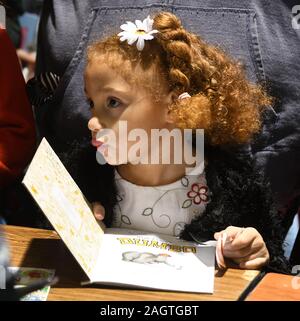 Racine, Wisconsin, USA. Dec 21, 2019. SANDRA SCHWARTZBARJER attend qu'un manuscrit de l'ancien Green Bay Packer star LeRoy Butler comme quelque 20 000 livres sont disponibles pour les enfants à Racine, Wisconsin de prendre gratuitement à la 17e édition de flics 'n Kids Book Giveaway à la salle des fêtes Samedi 21 décembre 2019. Then-Racine policier Julia Burney Witherspoon fondé les flics 'n Kids Reading Centre dans un quartier central de la ville en 2001 après avoir répondu à un appel à un cambriolage à l'entrepôt dans lequel des milliers de livres d'Or légèrement endommagées ont été stockées et prévue pour destructio Banque D'Images