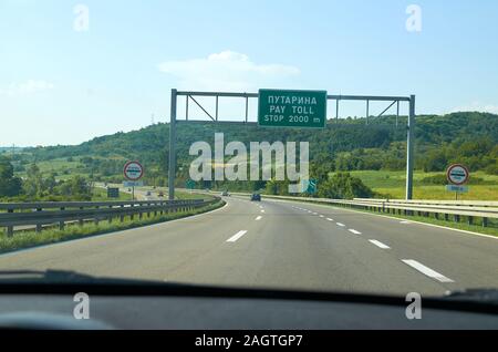 La circulation et les panneaux de circulation sur une route, annonçant un péage écrit en serbe Banque D'Images