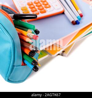 Fournitures scolaires diverses y compris les cahiers, crayons et calculatrice sur un fond blanc. Profondeur de champ avec une mise au point nette sur le crayon Banque D'Images