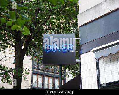 Une enseigne au néon lumineux lit Diner fixé à l'angle d'un ancien bâtiment du centre-ville sur une rue bordée d'arbres. Banque D'Images