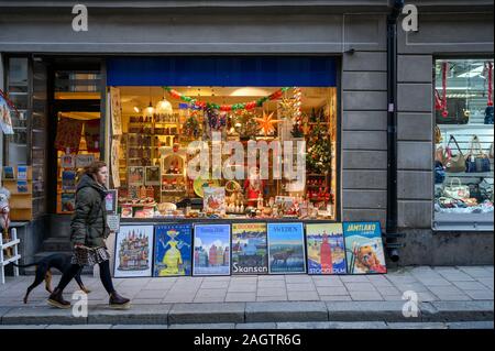 La Suède, Stockholm, le 18 décembre 2019 : ambiance de Noël de la ville. Les femmes de promenade avec chien le long de la rue commerçante de Gamla Stan. Vente de traditi Banque D'Images