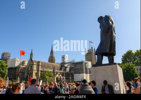 Londres - le 20 septembre 2019 : Statue de Winston Churchill donnant sur une rébellion protester contre l'extinction au Parlement Square, Londres, avec les maisons de P Banque D'Images