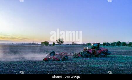 Une belle soirée d'été sur la terre campagne, dans les champs d'herbe et de terre labourée au coucher du soleil dans l'arrière-plan. Banque D'Images