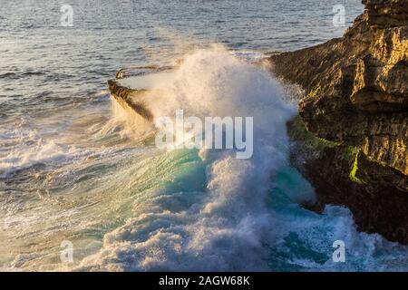 Vague géante s'écraser contre l'éperon rocheux au Devil's normale, sur la côte de Nusa Lembongan Island, Bali, Indonésie. Banque D'Images