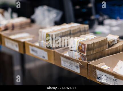 Grande quantité d'argent divisé et triés avec service de bandes et placés dans des boîtes en carton Banque D'Images