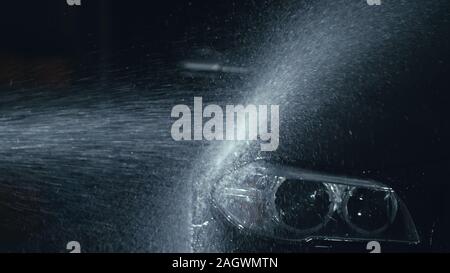 Phare de voiture lavage. Corps de véhicules modernes de Lavage par jet haute pression laver l'eau. flexible Auto Glass, projecteur angel eyes en gouttes. Banque D'Images