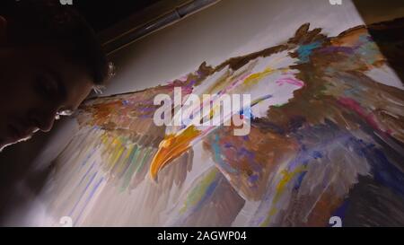 Concepteur de l'artiste dessine un aigle sur le mur. Décorateur artisan photo peintures à l'acrylique couleur d'huile. Peintre peintre vêtu de couche de peinture. À l'intérieur. Banque D'Images