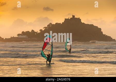 Marazion, Cornwall, UK. 22 décembre 2019. Les véliplanchistes ont été dehors pour le solstice d'hiver ce matin, lever du soleil sur la mer à Marazion, avec St Michaels Mount à l'arrière-plan. Simon crédit Maycock / Alamy Live News. Banque D'Images