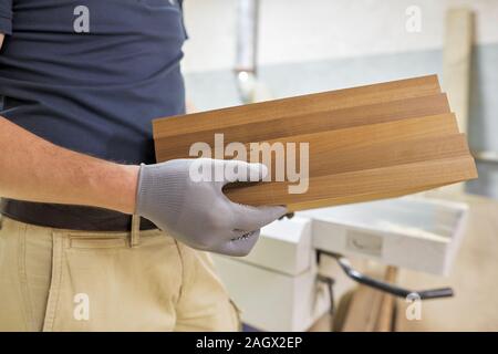 Close-up of carpenters mains avec planche bois Banque D'Images