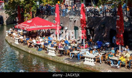 Vue de l'Oudegracht (Vieux canal) encombrée de touristes profitant de la météo à terrasses entre les quais et le canal. Utrecht, Pays-Bas. Banque D'Images