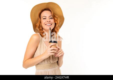 Portrait d'une fille charmante dans un chapeau avec une tasse de thé en papier sur un fond blanc Banque D'Images