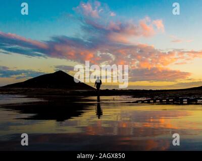 Personne à marcher vers la montagne rouge au coucher du soleil à Ténérife Banque D'Images