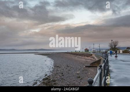 Largs, Ecosse, UK - 20 décembre 2019 : La ville de Largs, Dog Walkers avant que la pluie viennent de l'Argyle collines au loin. Banque D'Images