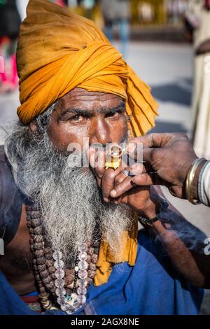 VARANASI, INDE - Le 18 mars 2017 : saint homme holding holding et pipe à Varanasi, Inde. Banque D'Images