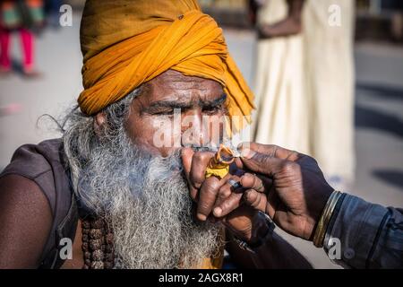 VARANASI, INDE - Le 18 mars 2017 : saint homme holding holding et pipe à Varanasi, Inde. Banque D'Images