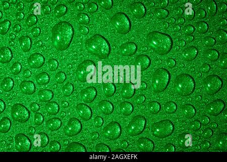 Un close up abstract macro photo de gouttelettes d'eau sur une poêle non stick gris avec un matériau gel flash vert Banque D'Images