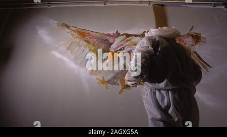 Concepteur de l'artiste dessine un aigle sur le mur. Décorateur artisan photo peintures à l'acrylique couleur d'huile. Peintre peintre vêtu de couche de peinture. À l'intérieur. Banque D'Images