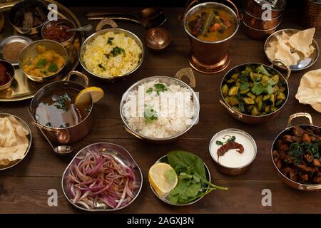 Variété de plats du sud de l'Inde sur une table en bois servi en cuivres traditionnels Banque D'Images