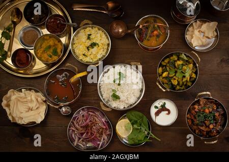 Variété de plats du sud de l'Inde sur une table en bois servi en cuivres traditionnels Banque D'Images