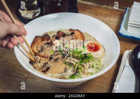 Tokotsu ramen délicieux style. Soupe japonaise avec des nouilles, flan de porc, œuf, bouillon de porc et légumes Banque D'Images