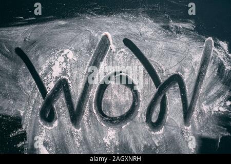 Déchiré en poudre dans la forme du mot WOW sur un tableau noir. Vue d'en haut Banque D'Images