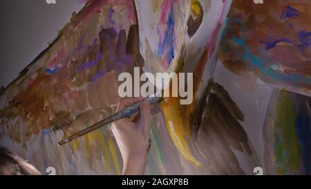 Concepteur de l'artiste dessine un aigle sur le mur. Décorateur artisan photo peintures à l'acrylique couleur d'huile. Peintre peintre vêtu de couche de peinture. À l'intérieur. Banque D'Images