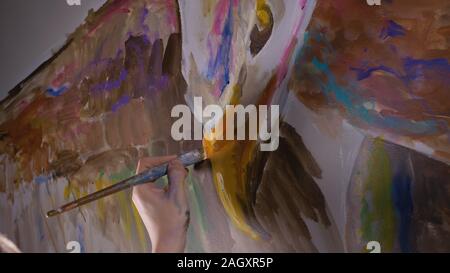 Concepteur de l'artiste dessine un aigle sur le mur. Décorateur artisan photo peintures à l'acrylique couleur d'huile. Peintre peintre vêtu de couche de peinture. À l'intérieur. Banque D'Images
