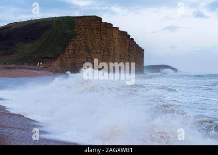 West Bay, Dorset, UK. 22 décembre 2019. Météo britannique. Des conditions dangereuses dans le village balnéaire de West Bay dans le Dorset comme d'énormes vagues s'écraser sur la terre ferme sur la plage. Crédit photo : Graham Hunt/Alamy Live News Banque D'Images