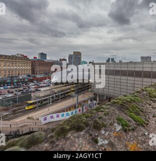 3007 tramway Metrolink Manchester au départ de Manchester Victoria en direction de l'est avec la ville derrière Banque D'Images