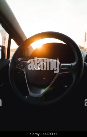 Toyota Avensis voiture cockpit volant dans la ville pendant le coucher du soleil Banque D'Images
