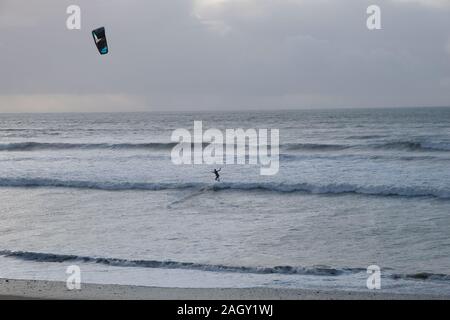 Marazion, Cornwall/UK- 22 décembre 2019 - un kitesurfeur surf pratiques près de Penzance, Cornwall, UK Banque D'Images