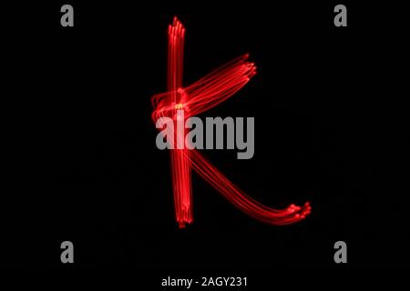 Light Painting Photographie de lettres de l'alphabet, dessiné par fairy lights en néon de couleur rouge sur fond noir. Photos à longue exposition. Banque D'Images