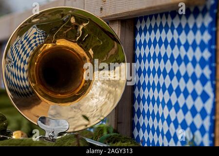 Gros plan d'une réflexion de tuba en laiton avec un papier peint en blanc et bleu motif de losange sur un wagon à un festival bavarois Banque D'Images