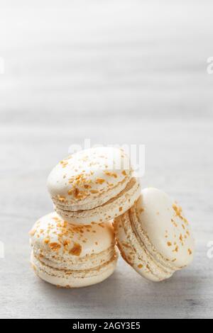 Macarons français. Pile de macarons praliné blanc sur fond gris. Copy space Banque D'Images