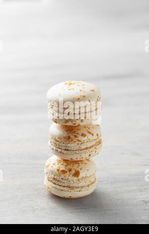 Macarons français. Pile de macarons praliné blanc sur fond gris. Copy space Banque D'Images