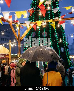 Minsk, Belarus - 21 décembre : Les personnes de moins de parapluie à un marché de Noël au centre-ville près de Julie Duquette marché. Pas de neige concept Banque D'Images