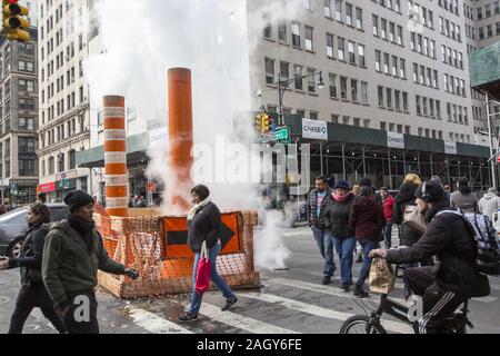 À partir de la vapeur sous la rue d'être libérés se mélange avec les piétons circulant le long de Broadway au centre-ville de Manhattan, New York. Banque D'Images