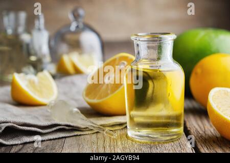 Bouteille de l'huile essentielle de citron et d'agrumes agrumes sur table. Banque D'Images