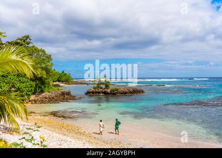 Couple en train de marcher sur une plage de sable fin, l'île de Tanna, Vanuatu Banque D'Images