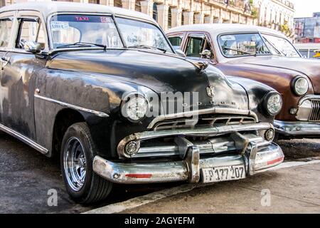 Une paire de voitures classiques des années 1950 stationné dans la vieille ville de la ville de La Havane, Cuba Banque D'Images