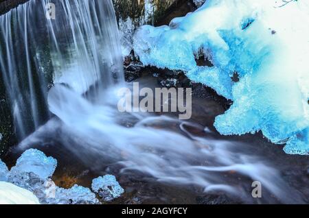 Détail de l'omble congelé - petite cascade, bleu glace, pierre, de glaçons et d'eau laiteuse Banque D'Images