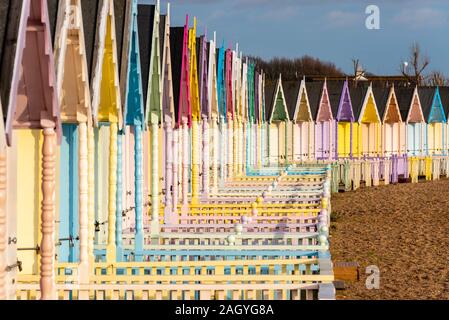 Cabines de plage en bois coloré à West Mersea, Mersea Island, Essex, UK lors d'une pause dans l'hiver. Décembre après-midi. Des couleurs vives Banque D'Images