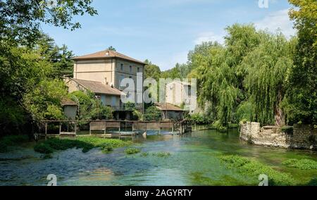 Une scène de rivière montrant une ancienne écluse au centre de Fontaine-de-Vaucluse Banque D'Images