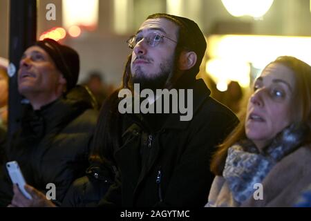 Un Juif orthodoxe regarde comme le plus grand menorah est allumé sur la première nuit des lumières", à New York, NY, le 22 décembre 2019. L'article 36 pieds de haut et pesant 400lbs, Hanukkah, connue comme la "fête des lumières" est célébrée pendant huit jours par des juifs dans le monde entier. (Anthony Behar/Sipa USA) Banque D'Images