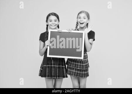 Équipe de l'initiative de camarades. Inscrivez-vous le club scolaire. Les élèves de la communauté. Cours de Cheerleading. L'annexe de l'école. School girls cute pupils uniforme rouge tenir copie tableau noir l'espace. Annonce école concept. Banque D'Images