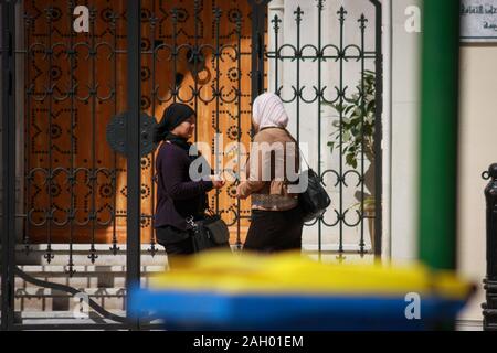 Deux Tunisiennes à cheveux couverts ont une discussion amicale devant la porte métallique de Sousse, en Tunisie Banque D'Images