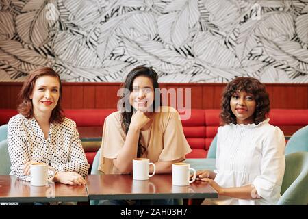 Multi-ethnic beautiful smiling woman enjoying délicieux café dans les coffeeshop et looking at camera Banque D'Images